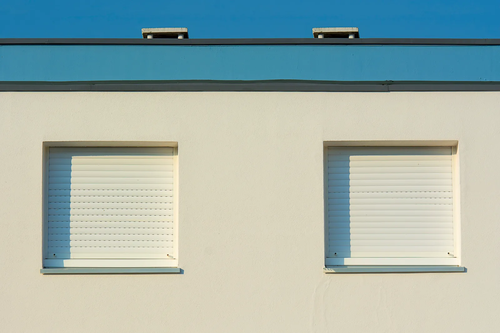 Hausfassade mit außenliegenden Rollläden – Symbolaufnahme