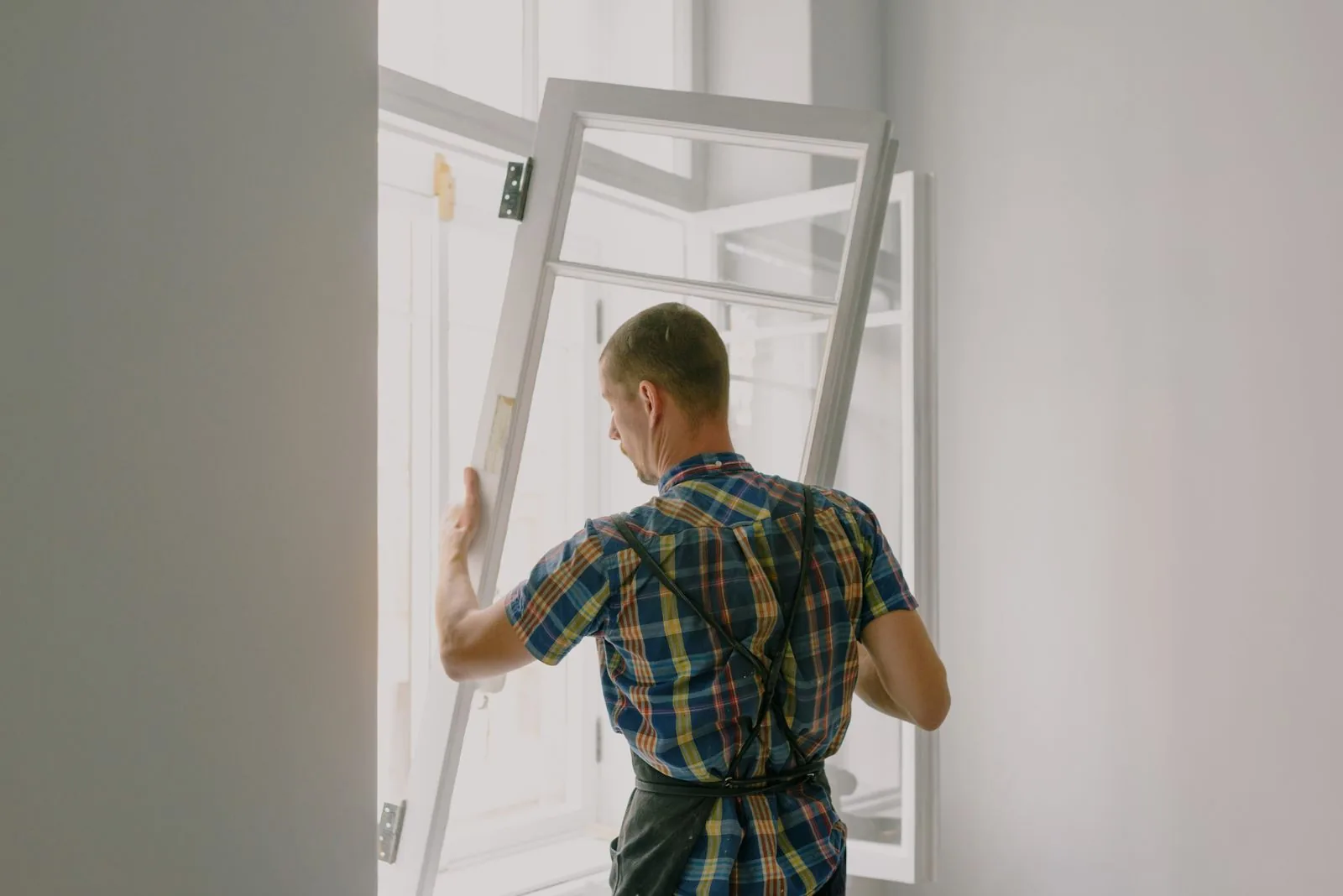 Handwerker bei der Montage eines Fensters – Symbolaufnahme